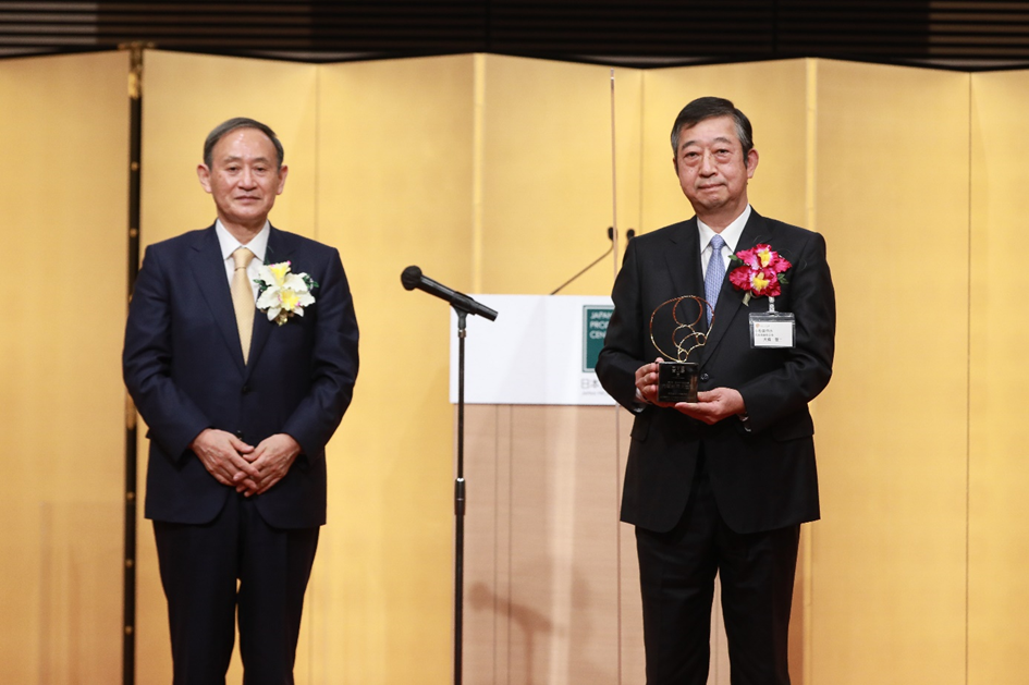 Mr. Yoshihide Suga handing over the award to Komatsu