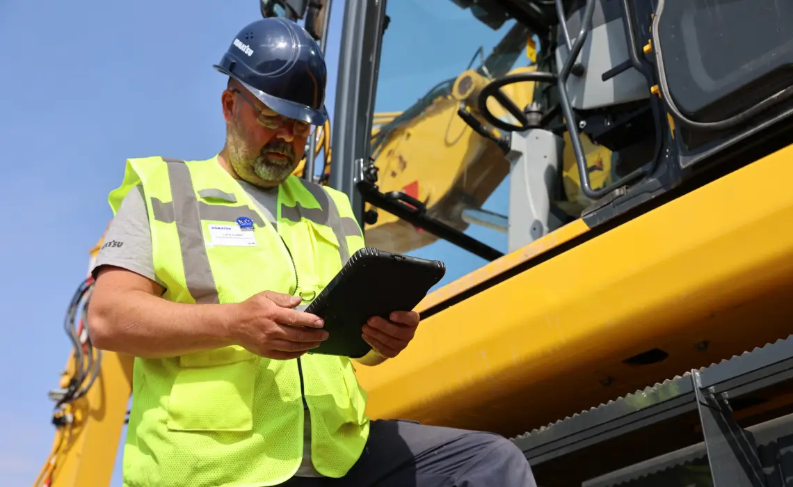 Picture of a man holding the Smart Construction 3D machine Guidance 10 inch tablet
